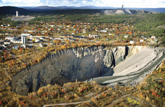 One of the open pits at the edge of Malmberget town. Main shaft and dumps from recent mining activity is seen at the upper left horizon. LKAB photo.