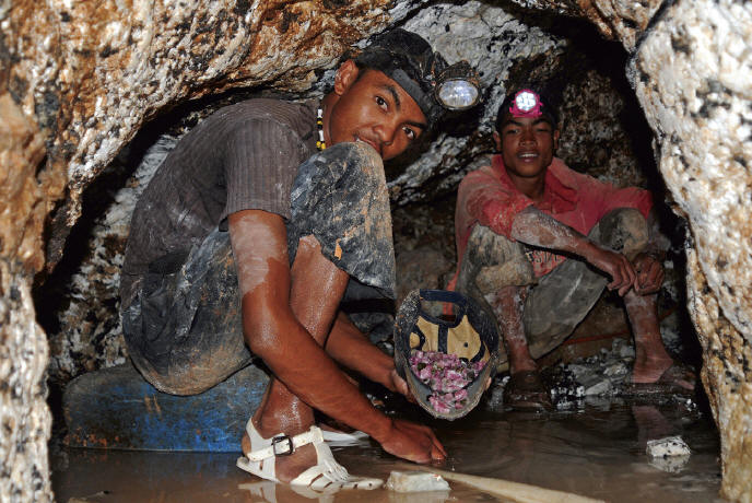 Miners working in narrow tunnels following pegmatite collecting fragments of gemmy rubelites. M. Lorenzoni photo.